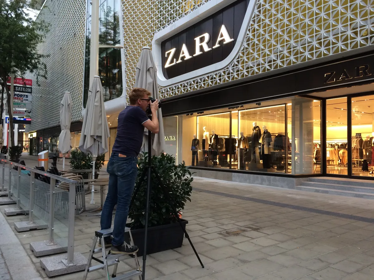 Wolfgang Lehner fotografiert von einer Leiter aus vor einer Zara-Filiale in Wien