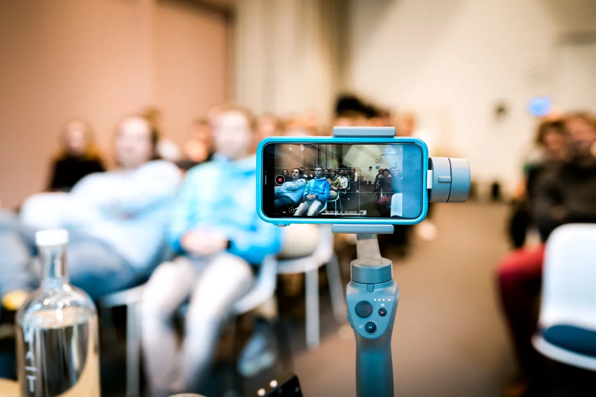 Smartphone auf einem Gimbal filmt das Publikum im Workshop